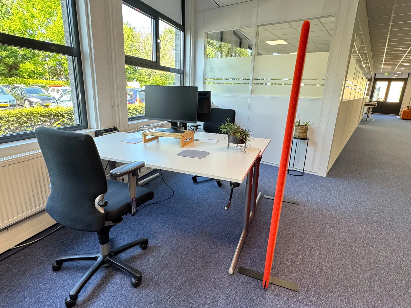 Flexwerkplekken met bureaustoelen langs het raam