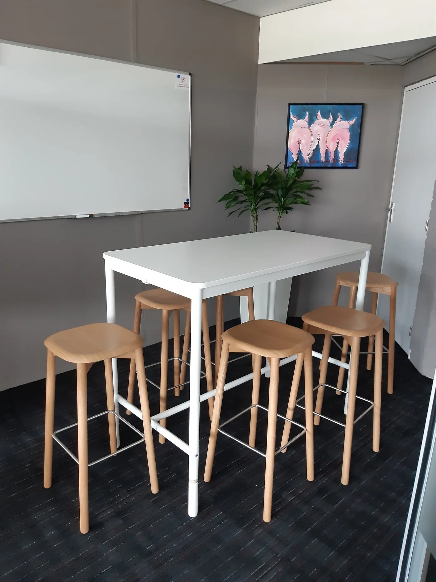 Statafel met krukken en een whiteboard in een overlegruimte