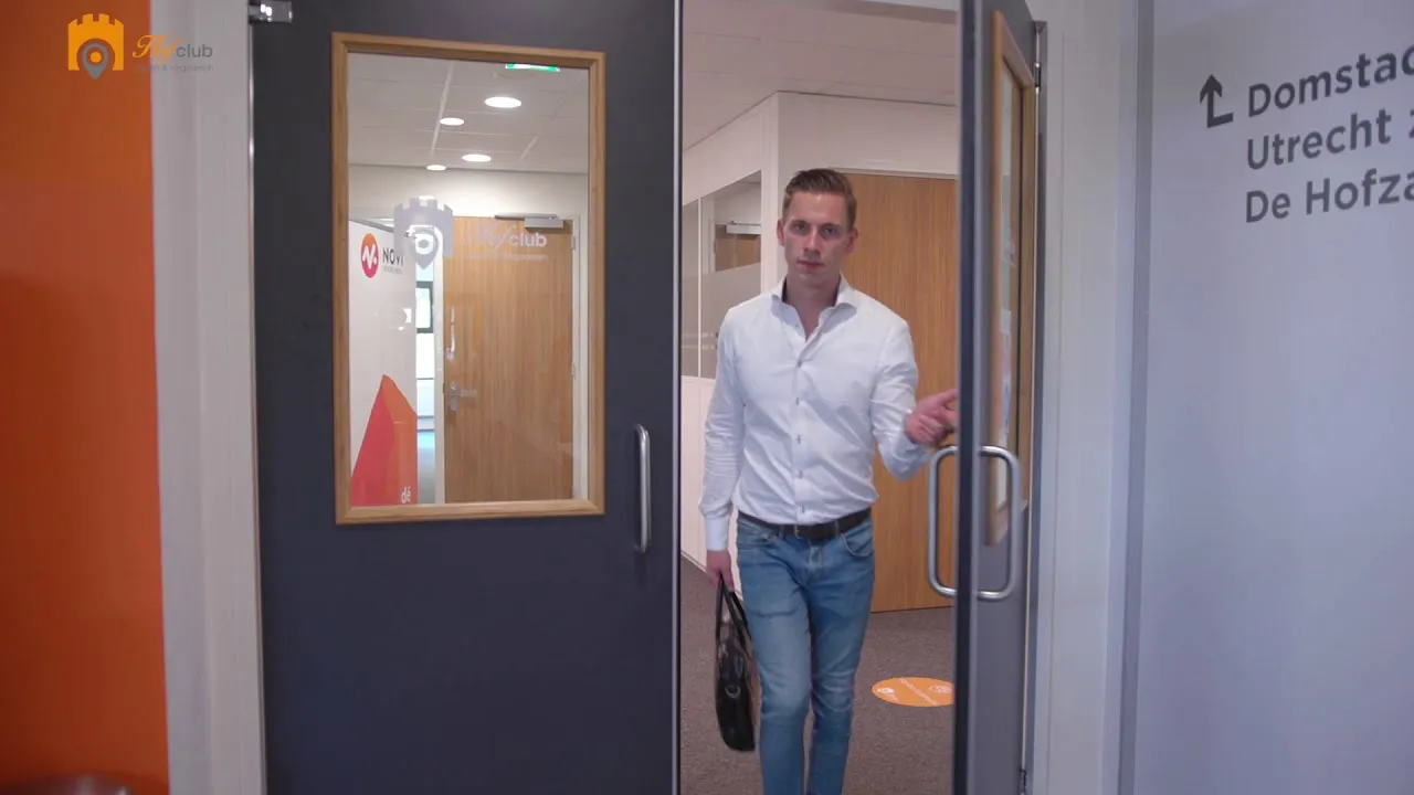 Videostill: iemand loopt door de entree van Hofclub